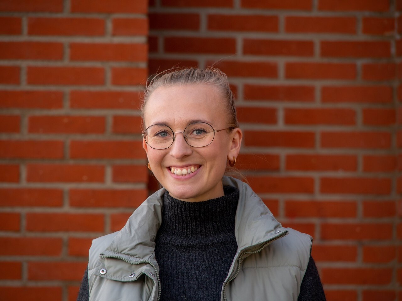 Projektledaren Linn Hoel framför en tegelvägg