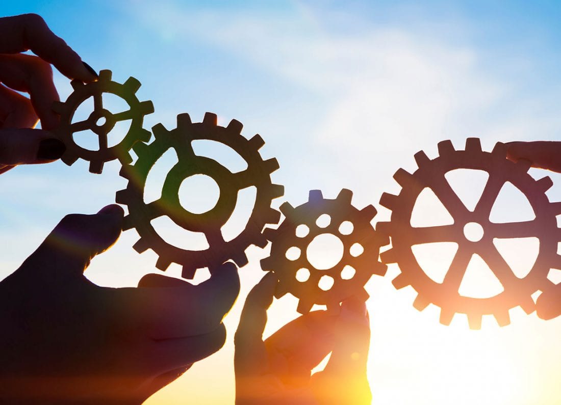 4-hands-holding-cogwheels-lores-1028168668-1100x795