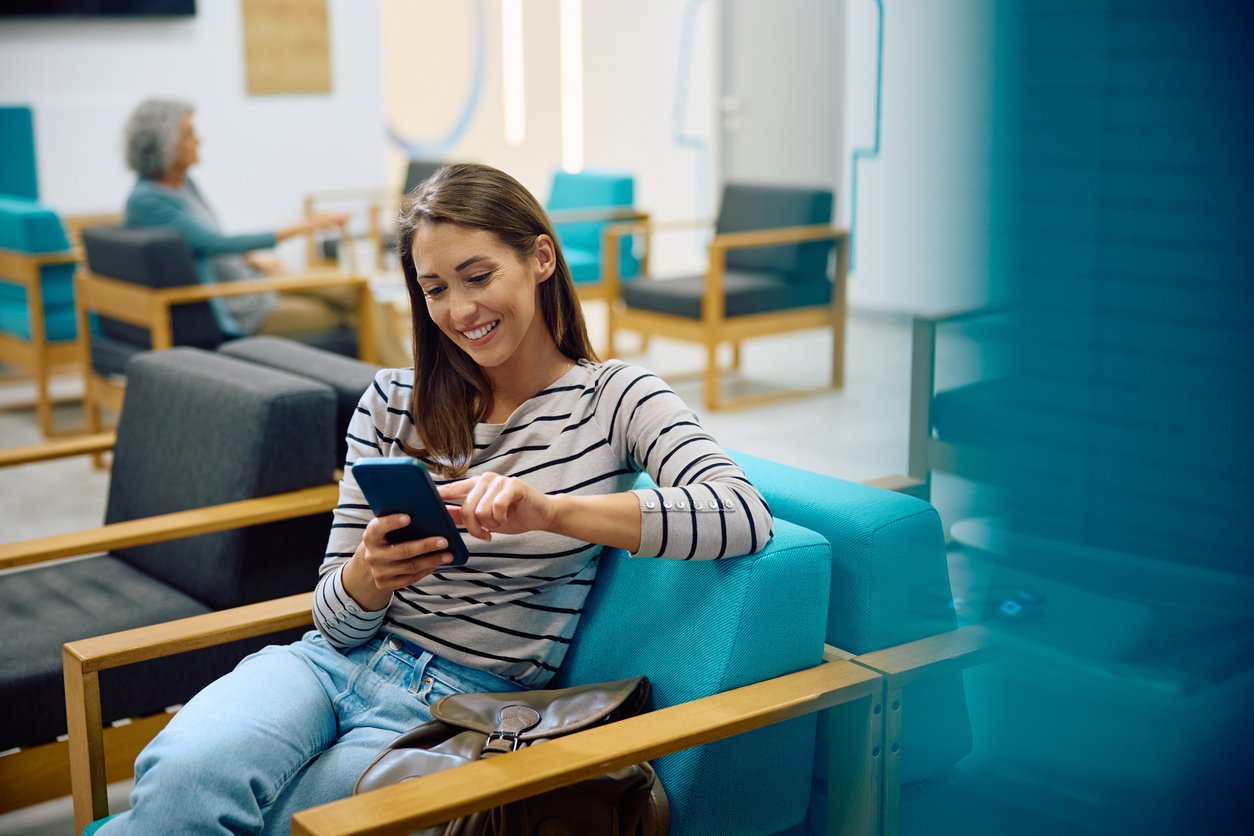 Woman happy with phone in waiting room