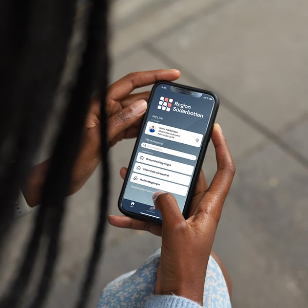 Kvinna tittar på vårdapp på smartphone